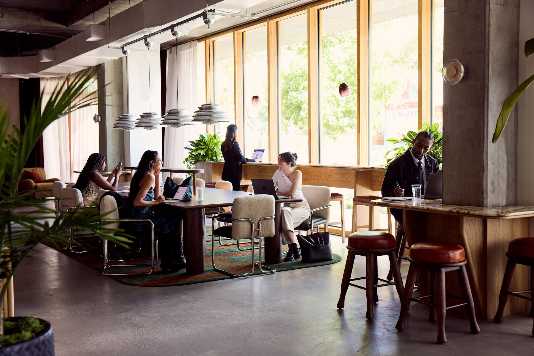 Open communal workspace with large windows at The Malin East Austin