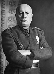 official portrait of Mussolini in uniform with crossed arms