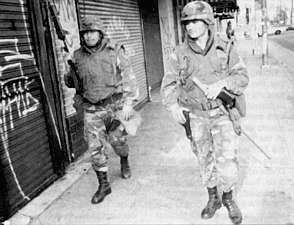 Armed national guardsmen patrol the streets of LA.