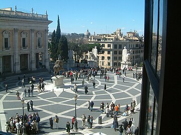 Plaza del Capitolio (Campidoglio) en Roma. De forma rectangular, la estructura del pavimento diseñado por Miguel Ángel destaca la escultura ecuestre de Marco Aurelio e integra con su dinamismo óptico la escalinata de acceso. El nombre deriva de la Colina Capitolina donde se asentó el centro del poder político en la Antigua Roma, y está en el origen del concepto capital (política) extendido a todos los estados del mundo.