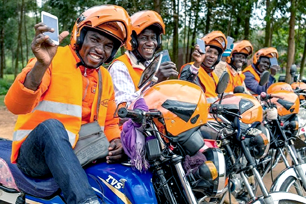 19 per cent of women in Uganda want to prevent or delay pregnancy but are not using a method of contraception. Photo: UNFPA/ © SafeBoda Motorcycle drivers line up and hold up their mobile phones.